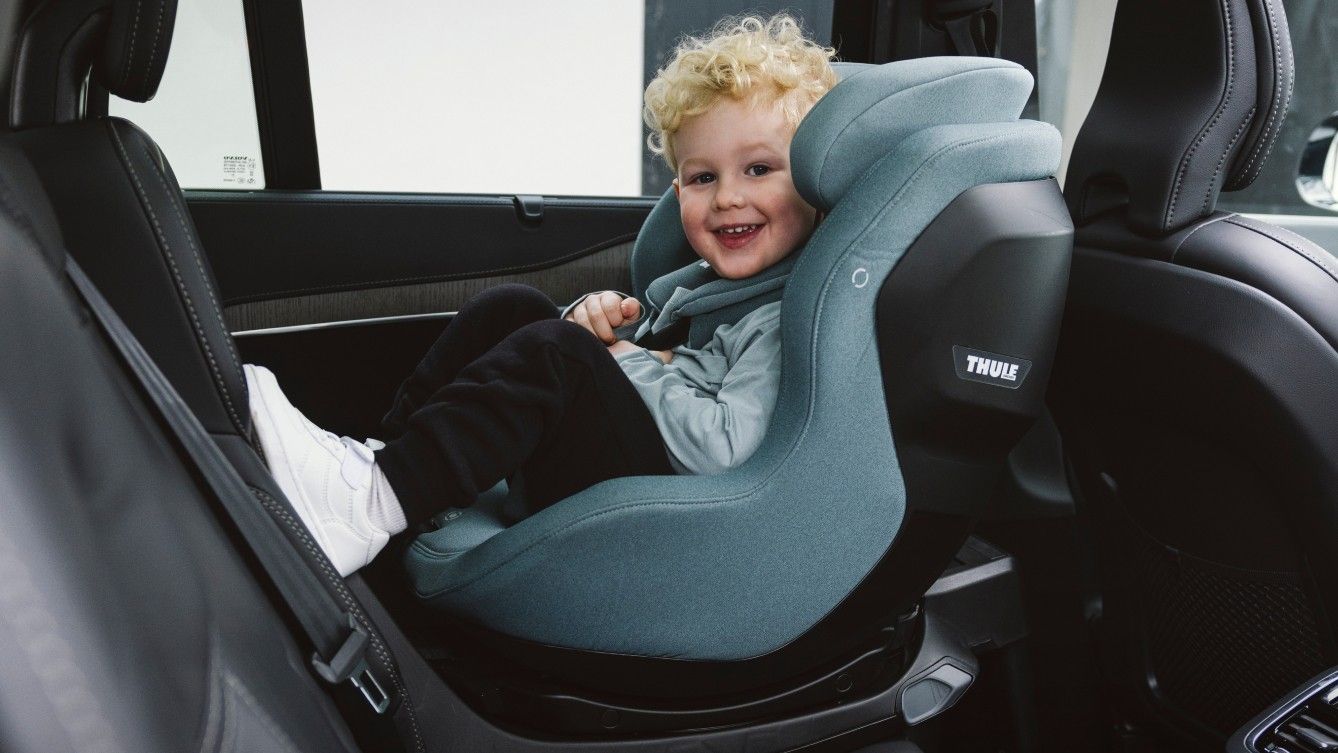 A toddler sitting in a Thule Elm rearward facing toddler car seat.