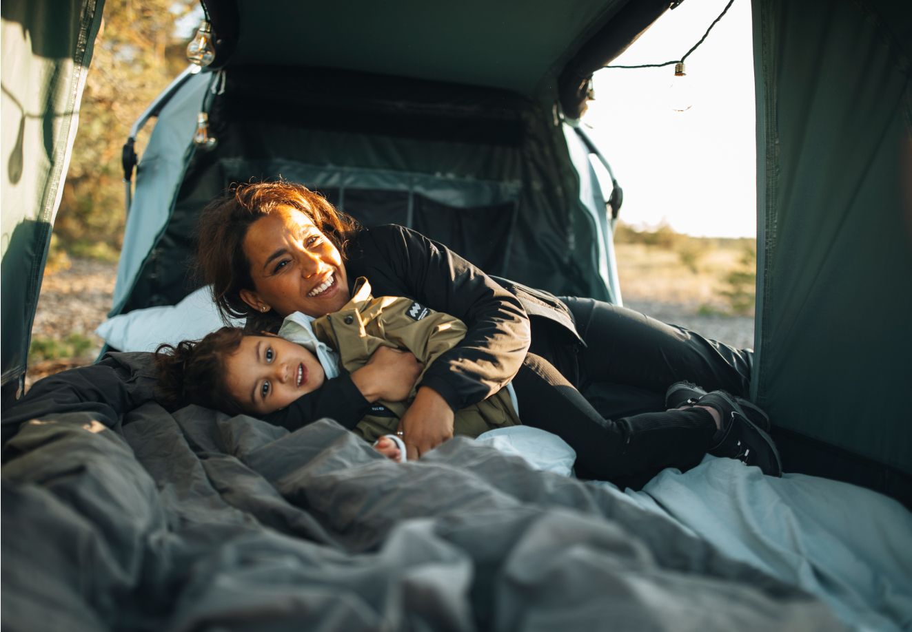 Adult and child play together in a Thule Outset car tent.