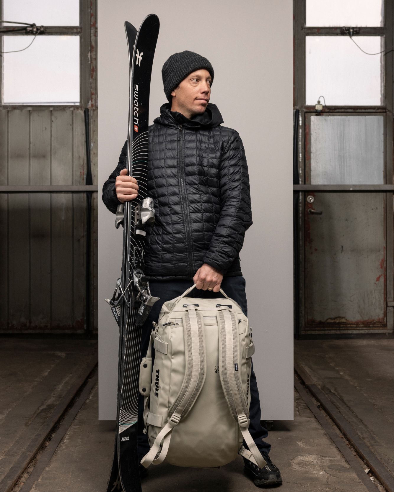 Sam Anthamatten stands with his skis in one hand and a Thule Chasm duffel bag in the other.