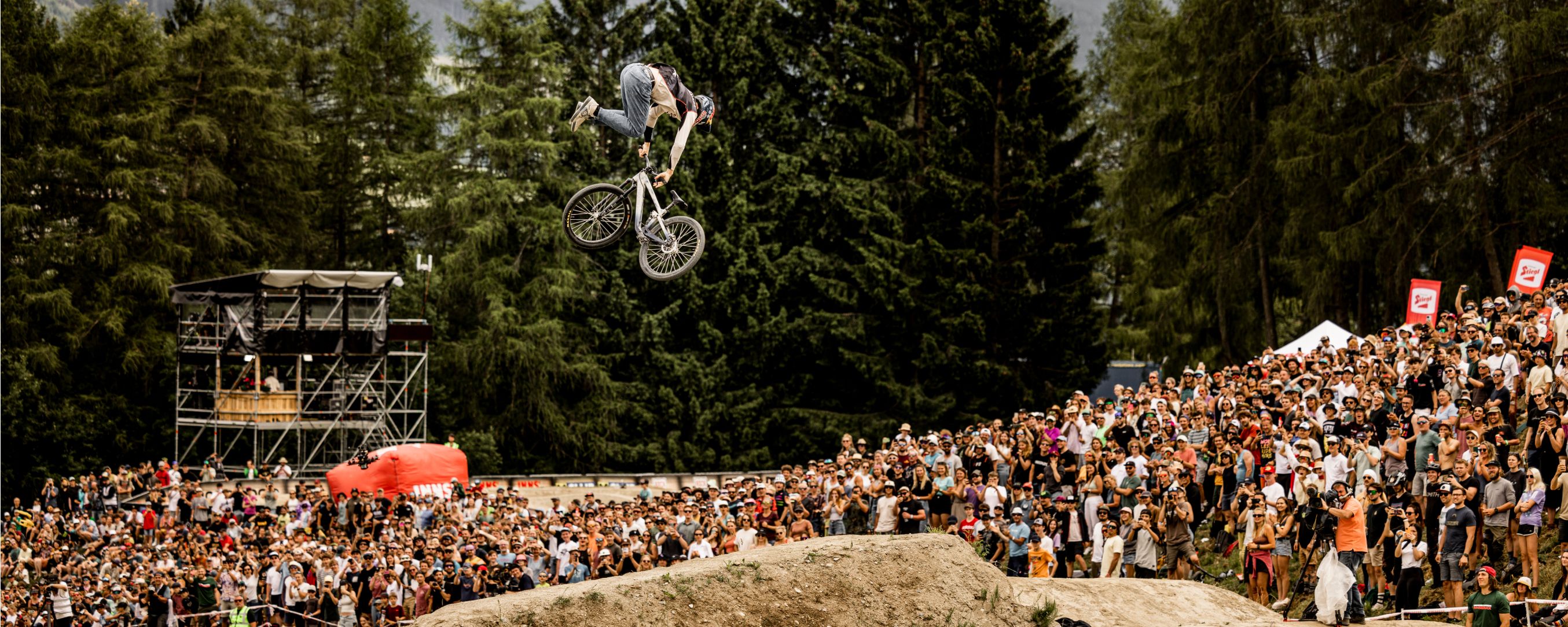 Ein Slopestyle-Radfahrer macht bei einem Slopestyle-Rennen einen riesigen Sprung.