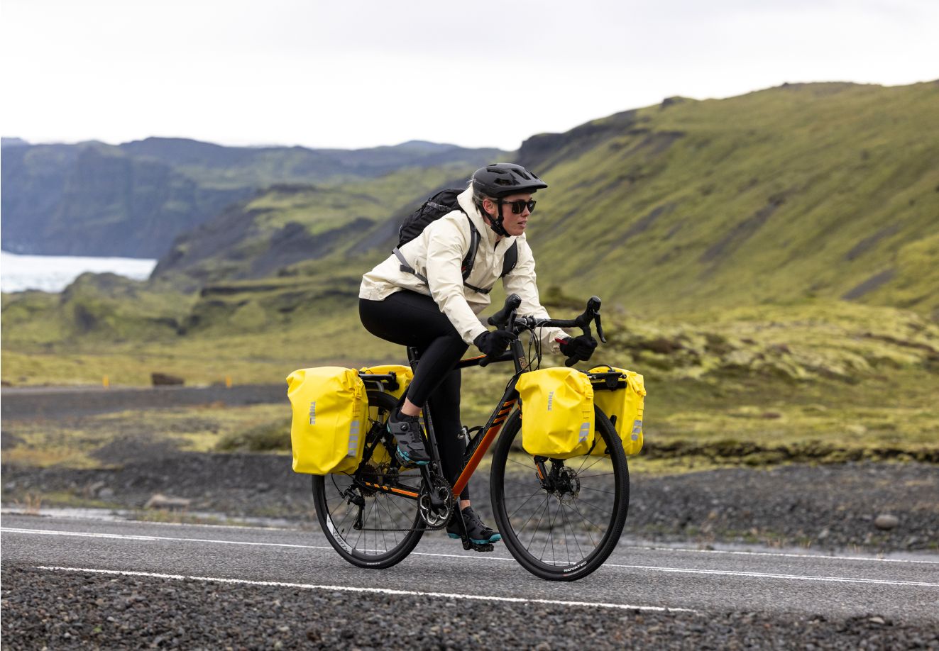 A bike packer is cycling in Iceland in rugged weather on a road.